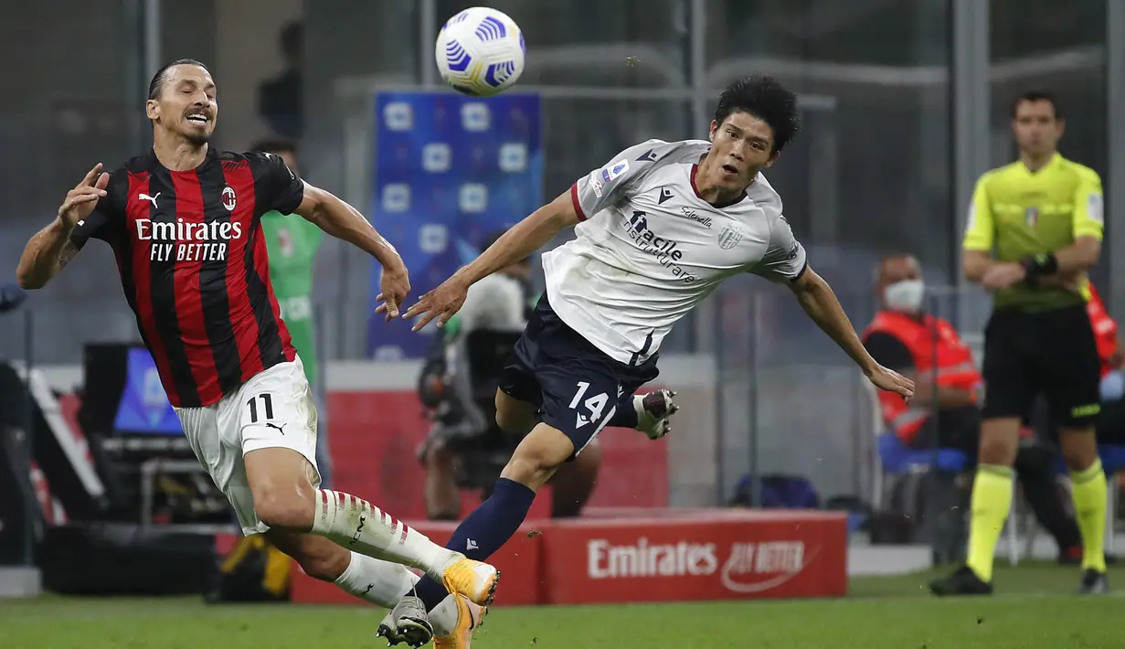 Pemain AC Milan Zlatan Ibrahimovic (kiri) berebut bola dengan pemain Bologna Takehiro Tomiyasu pada pertandingan Serie A di Stadion San Siro, Milan, Italia, Senin (21/9/2020). AC Milan menaklukkan Bologna 2-0. (AP Photo/Antonio Calanni)