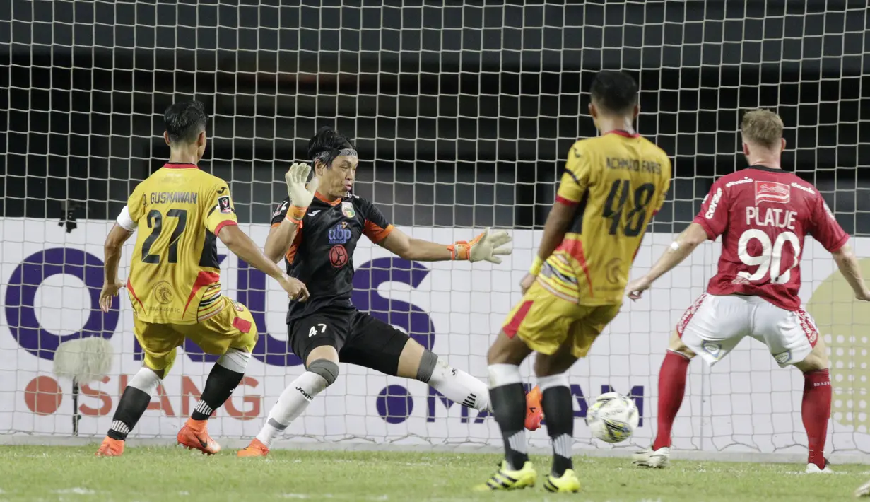 Kiper Mitra Kukar, Gerri Mandagi, gagal menghalau tendangan striker Bali United, Melvin Platje, pada laga Piala Presiden 2019 di Stadion Patriot, Jawa Barat, Minggu (3/3). Bali United menang 3-0 atas Mitra Kukar. (Bola.com/M Iqbal Ichsan)