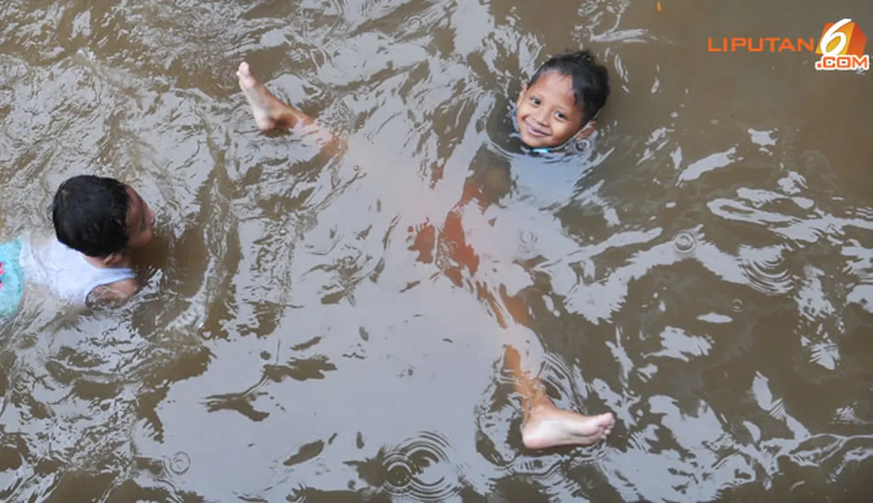 Anak-anak asyik bermain di tengah banjir. (Liputan6.com/Abdul Azis Prastowo)