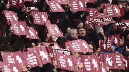 Suporter Torino membawa banner saat mendukung timnya melawan Juventus pada laga Serie A  di Stadio Grande Torino, Turin (18/2/2018). Juventus menang 1-0. (AFP/Marco Bertorello)