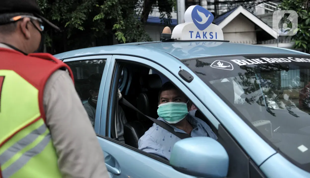 Petugas memeriksa jumlah penumpang salah satu taksi saat penindakan PSBB di kawasan Menteng, Jakarta, Senin (13/4/2020). Aturan bagi pengendara saat PSBB berlangsung antara lain wajib mengenakan masker dan sarung tangan bagi pengendara motor. (merdeka.com/Iqbal S. Nugroho)