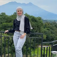 Berlatar gunung yang cantik, Aldila bergaya casual sporty dengan nuansa monokrom. Ia mengenakan blouse hitam yang dipadukan dengan celana jeans dan kerudung abu-abu. [instagram/dhila_bekti]