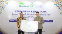 Direktur Utama PT Bank Muamalat Indonesia Tbk Indra Falatehan (kanan) dan Direktur Utama PT Pegadaian Damar Latri Setiawan (kiri) memperlihatkan mockup Perjanjian Kerja Sama (PKS) pendaftaran porsi haji reguler di Muamalat Tower, Jakarta, Jumat (17/11/2023). (Dok Muamalat)
