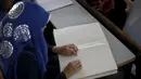 Seorang penyandang tunanetra ketika membaca Alquran versi Braille di Gaza, Palestina, Kamis (18/6). Bulan Ramadan, ribuan warga Palestina, termasuk penyandang tunanetra mendapat pelajaran membaca dan menghafal Alquran secara gratis. (REUTERS/Suhaib Salem)