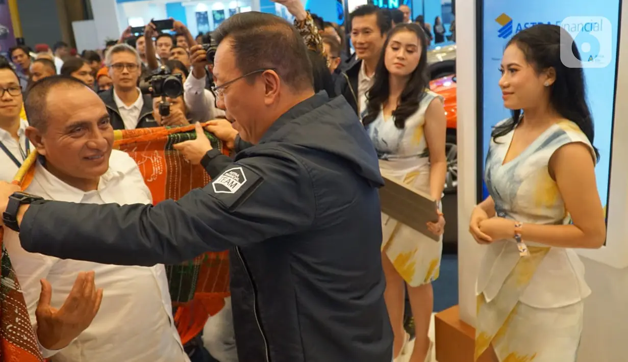 Gubernur Sumatera Utara Edi Rahmayadi saat mengunjungi booth dan dikenakan ulos oleh Project Director GIIAS 2019 Gunawan Salim di GIIAS 2019 Medan, Rabu (23/10/2019). (Liputan6.com/HO/Eko)