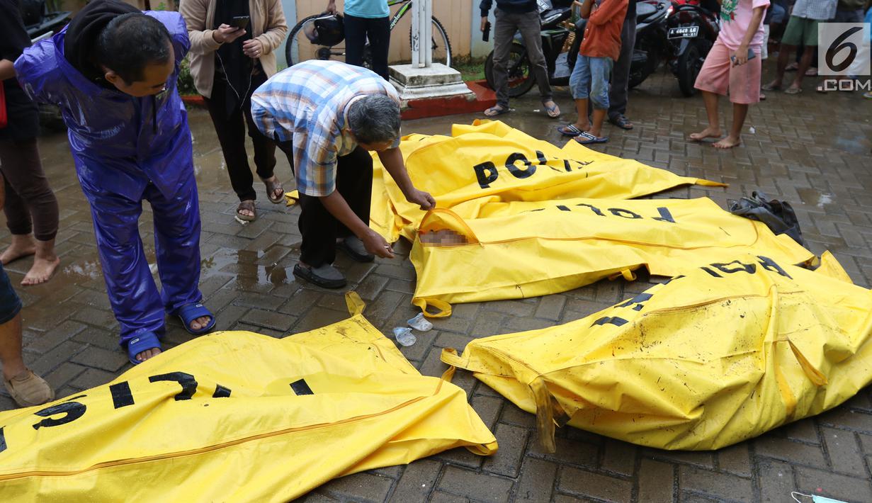 Warga melihat jenazah korban gelombang Tsunami Anyer di Puskesmas Carita, Banten, Minggu (23/12). Tim SAR masih melakukan pencarian jenazah yang sebagian besar berasal dari Pantai Carita. (Liputan6.com/Angga Yuniar)