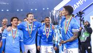 Gelandang Napoli, Scott McTominay (kedua dari kiri) melihat rekan setimnya, Giovanni Di Lorenzo, mencium trofi juara Piala Super Italia 2025 di King Al-Awwal Park Stadium, Riyadh, Selasa (23/12/2025) dini hari WIB. (Fayez NURELDINE / AFP)