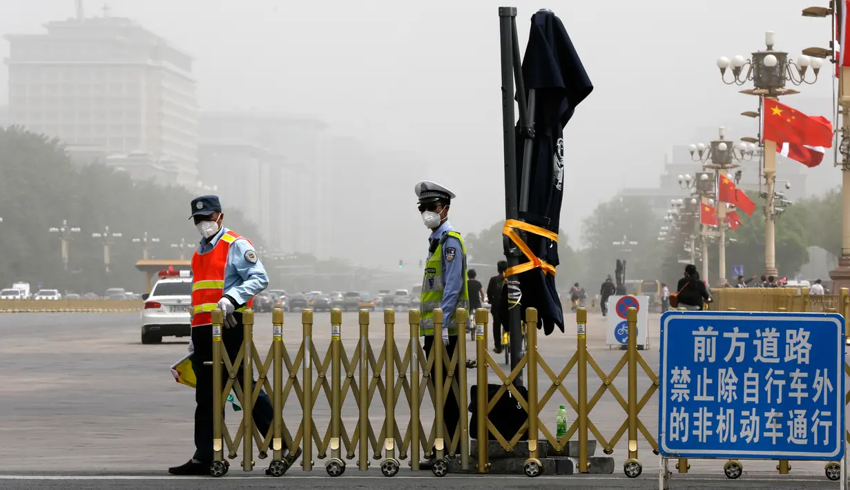 Petugas menutup jalur sepeda dekat Lapangan Tiananmen saat badai debu menerjang kota Beijing, China, Kamis (4/5). Badai debu menyebabkan warga harus menutupi mulut dan hidung mereka dengan masker dan bandana. (AP Photo/Andy Wong)