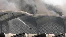 Pasukan Pertahanan Sipil Arab Saudi memadamkan kebakaran yang melanda Stasiun Kereta Api Cepat Haramain di kota Jeddah, Minggu (29/9/2019). Kebakaran terjadi pada pukul 12.35 waktu setempat di atap lantai empat gedung stasiun. (Photo by - / AFP)