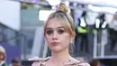 Aimee Lou Wood berpose di depan fotografer saat tiba untuk pemutaran perdana film 'Living' selama Festival Film London 2022 di London, Minggu, 9 Oktober 2022. Dia menata gaun emasnya dalam sanggul yang rapi, memamerkan anting-anting mutiara yang apik. (Photo by Vianney Le Caer/Invision/AP)