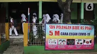 Murid berbaris memasuki ruang kelas saat pembelajaran tatap muka (PTM) terbatas di SDN Pisangan Baru 05 Pagi, Jakarta, Senin (8/11/2021). Pembekalan anak akan pemahaman protokol kesehatan di sekolah saat pandemi COVID-19 merupakan kewajiban orangtua dan guru. (merdeka com/Iqbal S. Nugroho)