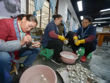 Para pekerja tampak sibuk di sebuah bengkel pembuatan kerajinan perak di Wilayah Danzhai, Provinsi Guizhou, China pada 17 November 2020. Menjelang perayaan Tahun Baru Etnis Miao, sebuah bengkel pembuatan produk perak memasuki musim puncak penjualan. (Xinhua/Yang Ying)