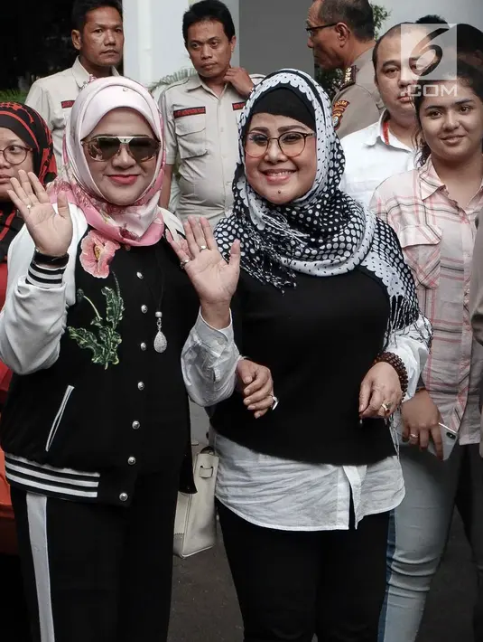 Elvy Sukaesih ditemani anaknya Fitria Sukaesih menyapa awak media usai menjalani pemeriksaan di Ditresnarkoba Polda Metro Jaya, Jakarta, Senin (26/2). Elvy mengaku belum sempat menjenguk putra putrinya di sel tahanan. (Liputan6.com/Faizal Fanani)