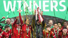 Pelatih Liverpool, Jurgen Klopp, mengangkat trofi juara Carabao Cup 2023/2024 di Stadion Wembley, Minggu (25/2/2024). The Reds menang lewat gol dramatis yang dicetak oleh Virgil van Dijk di menit Menit ke-118. (AP Photo/Alastair Grant)