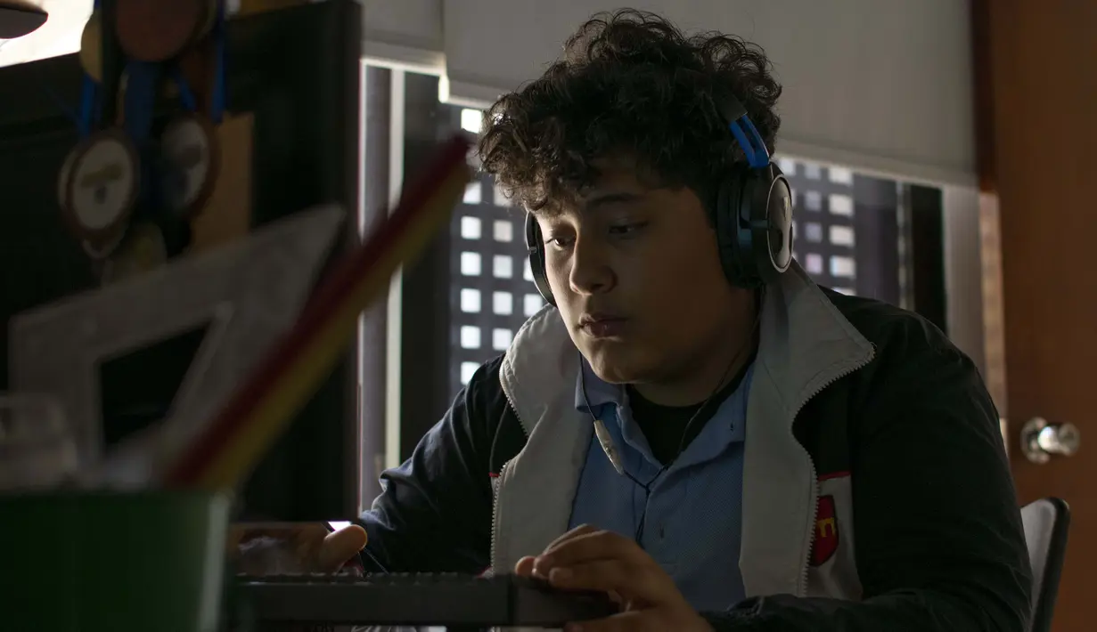 Luciano Rodriguez, 13, mendengarkan kelas sejarah online di rumahnya di La Boyera di Baruta, Caracas, 7 Oktober 2020. Di tengah pandemi, kelas dimulai lagi di Venezuela dengan siswa yang harus mencari sinyal internet di jalan dan guru berpenghasilan 2,5 dolar AS sebulan (Cristian Hernandez/AFP)