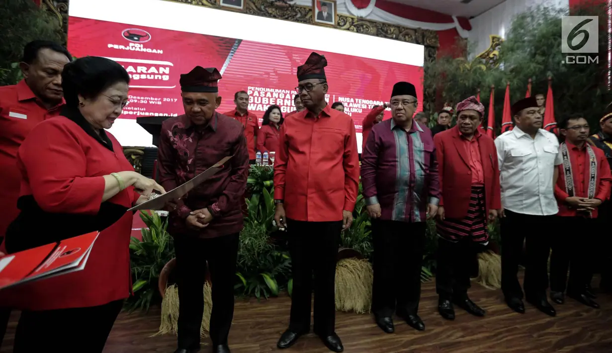 Ketum PDIP Megawati Soekarnoputri menyerahkan dokumen kepada pasangan cagub-cawagub PDIP di Kantor DPP PDIP, Jakarta, Minggu (17/11). Megawati mengumumkan pasangan cagub-cawagub Riau, Sultra, NTT dan Maluku. (Liputan6.com/Faizal Fanani)