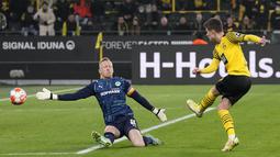Gelandang Borussia Dortmund Thorgan Hazard mencetak gol ketika kiper Greuther Fuerth Sascha Burchert mencoba menghentikannya pada laga pekan ke-16 Bundesliga di Signal Iduna Park, Kamis (16/12/2021) dini hari WIB. Dortmund mampu meraih kemenangan 3-0 atas Greuther Fuerth. (AP Photo/Martin Meissner)