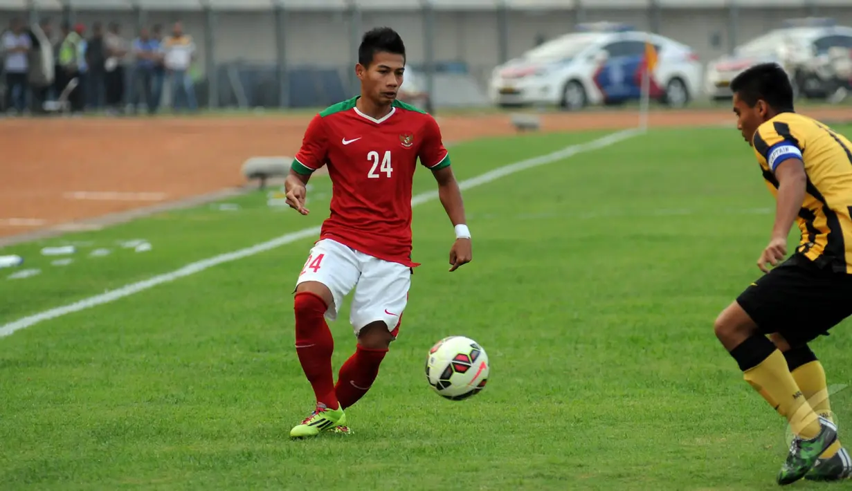 Gelandang Timnas Indonesia U-23, Ahmad Nufiandani (kiri) mencoba mengecoh pemain Malaysia U-23 saat laga uji coba di Stadion Si Jalak Harupat, Bandung, Kamis (21/5/2015). Indonesia unggul 1-0 atas Malaysia. (Liputan6.com/Helmi Fithriansyah)
