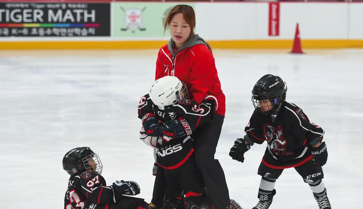 Hwangbo Young melatih anak-anak selama kelas hoki di gelanggang es di Seoul (4/4). Kiprah Hwangbo Young sebagai pemimpin tim hoki es nasional Korea Selatan mencapai puncaknya pada tahun 2005. (AFP Photo / Jung Yeon-Je)