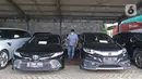 Petugas beraktivitas di dekat kendaraan sitaan dari tersangka tindak pidana korupsi PT Asabri di Kantor Pusat PT ASABRI (Persero), Cawang, Jakarta, Sabtu (12/6/2021). Lelang mobil hasil sitaan kasus korupsi PT Asabri dilakukan pada 15 Juni 2021 pukul 09.00-11.00 WIB. (Liputan6.com/Herman Zakharia)