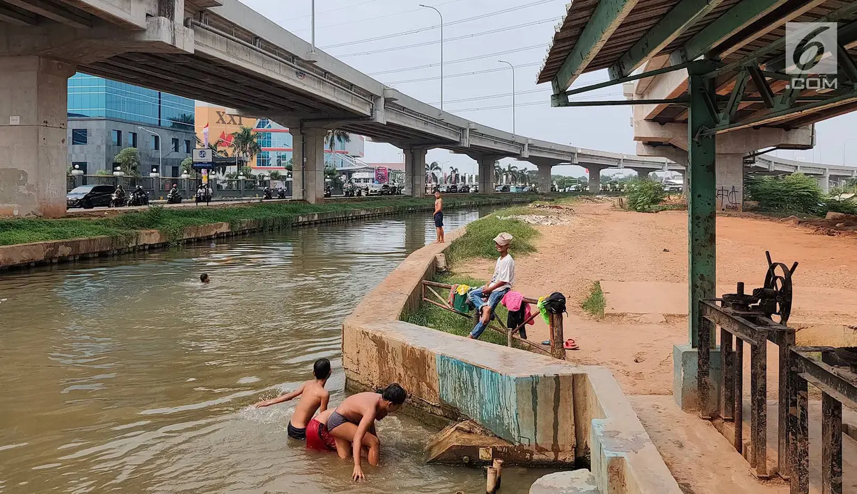 Anak-anak bermain dan berenang di Sungai Kalimalang, Jakarta Timur, Jumat (5/7/2019). Tingginya suhu udara Ibu Kota akibat musim kemarau menyebabkan anak-anak tersebut berenang di Sungai Kalimalang meski dengan kondisi seadanya. (Liputan6.com/Immanuel Antonius)