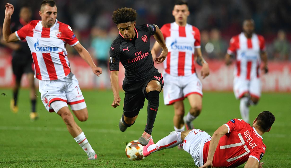 Pemain Arsenal, Reiss Nelson (tengah) menghindar dari terjangan pemain  Belgrade Crvena Zvezda, Marko Gobeljic pada laga grup H Liga europa di Stadion Rajko Mitic, (19/10/2017). Arsenal menang 1-0. (AFP/Andrej Isakovic)