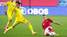 Pemain Norwegia, Martin Odegaard, berebut bola dengan pemain Rumania, Ianis Hagi, pada laga UEFA Nations League di Stadion Ullevaal, Minggu (11/10/2020). Norwegia menang dengan skor 4-0. (Vidar Ruud /NTB scanpix via AP)