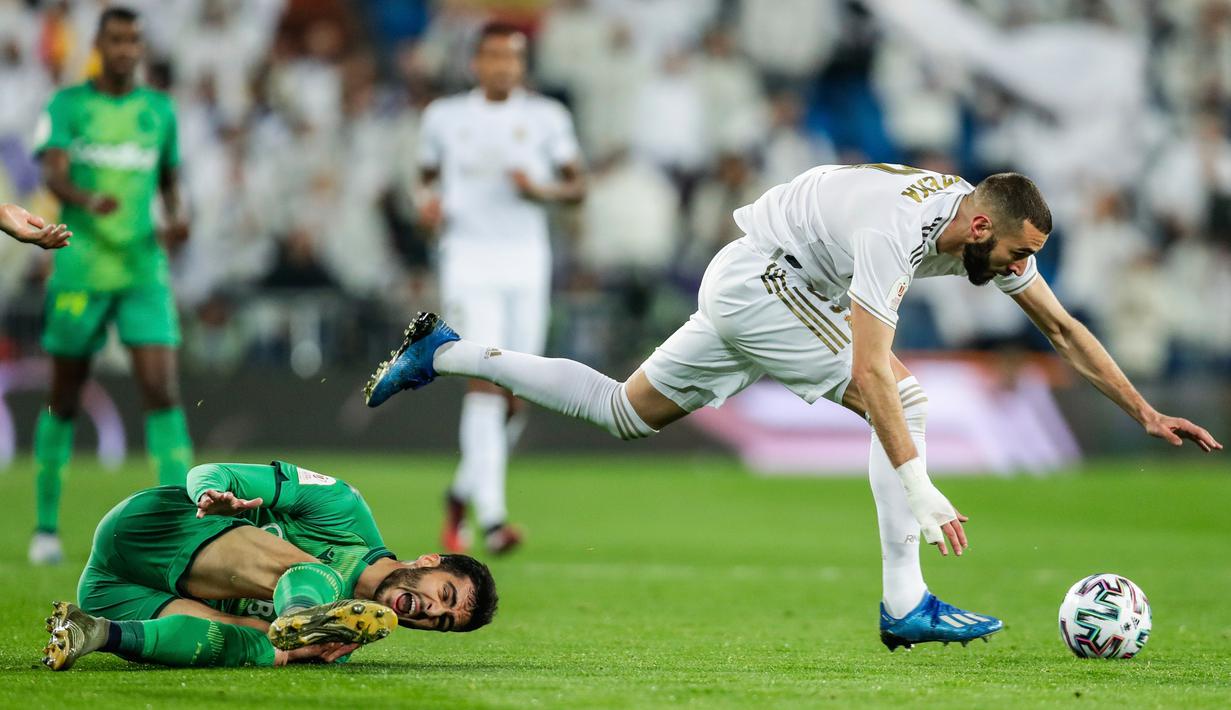 Striker Real Madrid, Karim Benzema melewati pemain Real Sociedad, Mikel Merino selama laga perempat final Copa del Rey di Santiago Bernabeu, Kamis (6/2/2020). Real Madrid gagal melaju ke semifinal Copa del Rey setelah dibungkam Real Sociedad dengan skor 3-4. (AP Photo/Manu Fernandez)