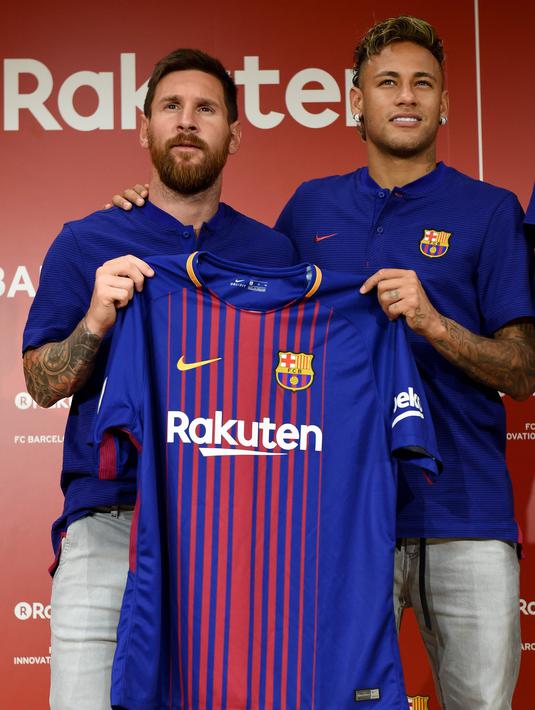 Pemain Barcelona, Lionel Messi dan Neymar menunjukan jersey baru La Blaugrana di Tokyo, Jepang (13/7).  Barcelona resmi merilis jersey baru dengan Rakuten sebagai sponsor utama musim ini. (AFP/Toru Yamanaka)