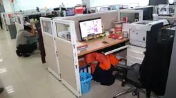 Pekerja berlindung di bawah meja saat simulasi bencana di Gedung Graha BNPB, Jakarta, Kamis (26/4). Disimulasikan telah terjadi gempa 7,5 skala Richter di pesisir selatan Pulau Jawa. (Liputan6.com/Arya Manggala)