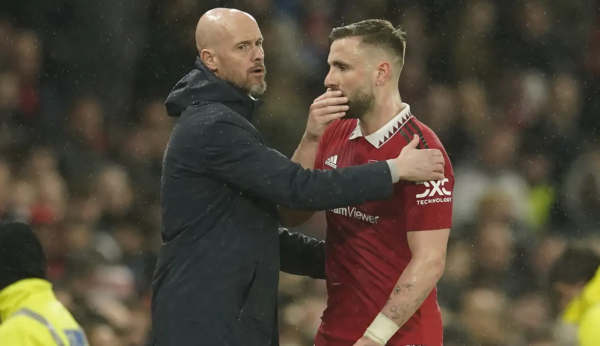 Bek Manchester United, Luke Shaw berbisik kepada pelatih Erik ten Hag setelah ditarik keluar akibat cedera saat menghadapi Brentford pada laga lanjutan Liga Inggris 2022/2023 di Old Trafford Stadium, Manchester, Kamis (6/4/2023) dini hari WIB. (AP Photo/Dave Thompson)