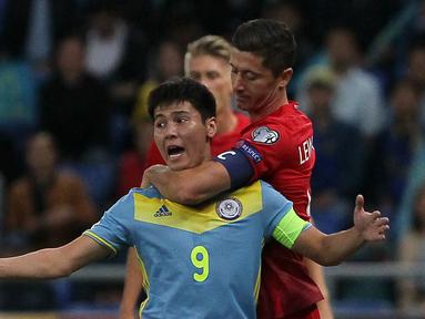 Pemain Polandia, Robert Lewandowski saat menghalangi protes pemain Kazakhstan, Bauyrzhan Islamkhan pada babak kualifikasi piala dunia 2018 di Astana (5/9/2016) dini hari WIB. (AFP/ Stanislav Filippov)