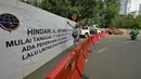 Pekerja memasang spanduk pengumuman pengalihan arus lalu lintas akibat adanya proyek pembangunan jalur kereta Light Rail Transit (LRT) di Jalan Setiabudi Tengah, Jakarta, Senin (17/6/2019). Penutupan untuk memberi ruang terkait pengerjaan konstruksi jalur LRT. (Liputan6.com/Herman Zakharia)