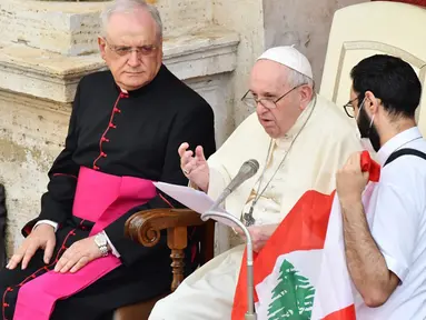 Paus Fransiskus berbicara tentang situasi Lebanon saat seorang imam Lebanon (kanan) memegang bendera Lebanon dan Monsinyur Leonardo Sapienza (kiri) menyaksikan audiensi publik terbatas di halaman San Damaso, Vatikan, Rabu (2/9/2020). (Vincenzo PINTO/AFP)