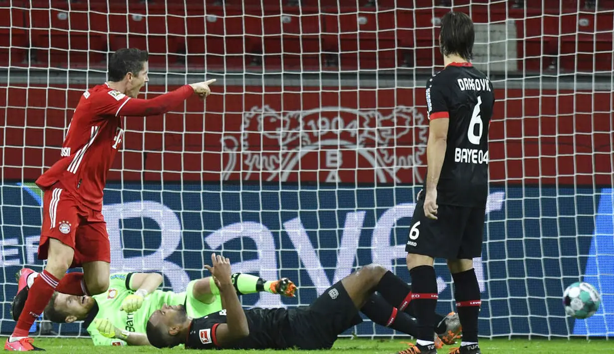 Striker Bayern Munchen, Robert Lewandowski, mencetak gol ke gawang Bayer Leverkusen pada laga Bundesliga di Stadion BayArena, Minggu (20/12/2020). Bayern Munchen menang dengan skor 2-1. (Bernd Thissen/Pool Photo via AP)