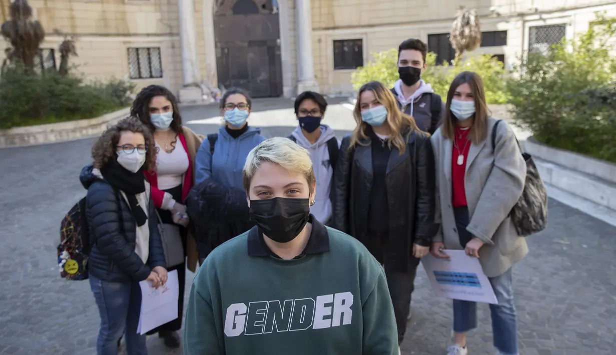 Matteo Coccimiglio berfoto bersama teman-teman sekolahnya di depan sekolah seni Ripetta di Roma, 24 Maret 2021. Siswa 18 tahun itu mengidentifikasi dirinya sebagai laki-laki, dan sedang dalam proses mengubah status gendernya dari perempuan menjadi pria. (AP Photo/Alessandra Tarantino)