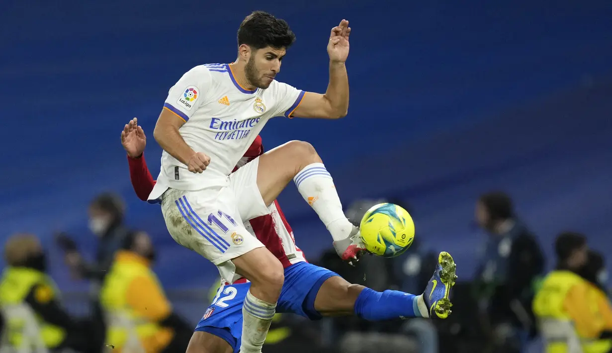 Penyerang  Real Madrid Marco Asensio berebut bola dengan bek Atletico Madrid Renan Lodi pada pekan ke-17 Liga Spanyol di Santiago Bernabeu, Senin dini hari WIB (13/12/2021). Real Madrid berhasil menaklukkan rival sekotanya Atletico Madrid dengan skor 2-0. (AP Photo/Bernat Armangue)