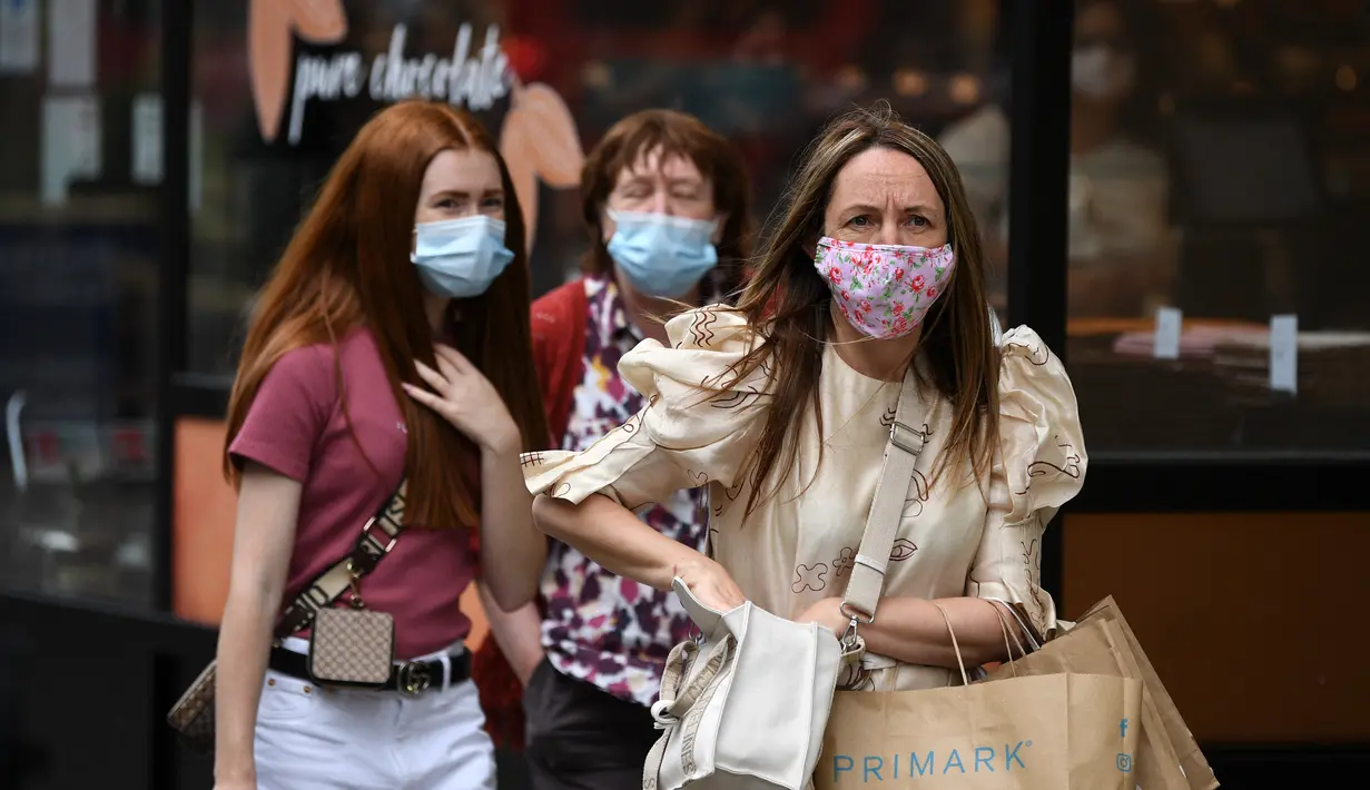 Pembelanja yang mengenakan masker berjalan di sepanjang Oxford Street di pusat kota London, Senin (5/7/2021). Perdana Menteri Boris Johnson telah menetapkan rencana mengakhiri pembatasan sosial dan ekonomi terkait COVID-19 di Inggris pada 19 Juli 2021. (DANIEL LEAL-OLIVAS/AFP)
