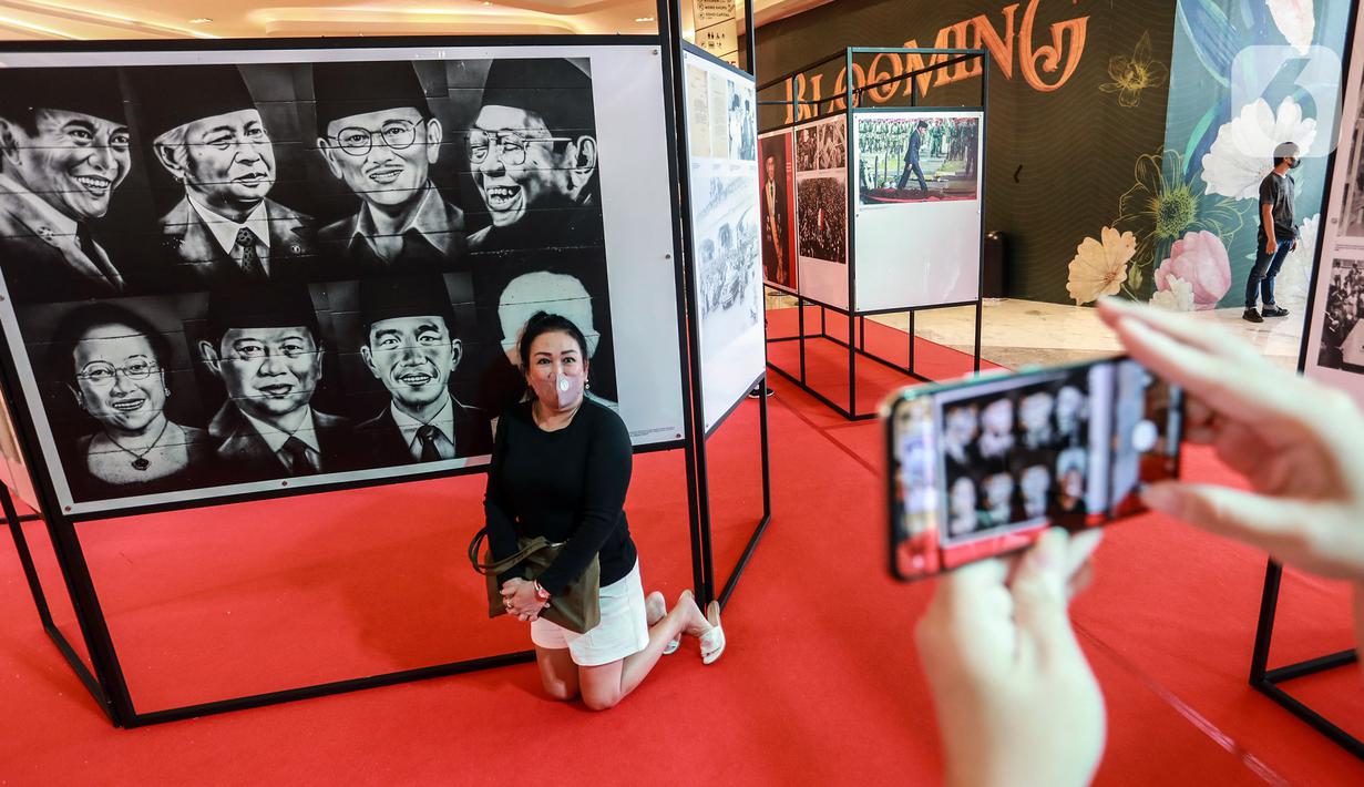 Pengunjung berfoto saat Pameran Foto Potret 7 Presiden RI dengan tema "7 Citizen No.1" di Mall Neo Soho, Jakarta, Selasa (22/11/2022). Foto-foto yang dipamerkan merupakan foto bersejarah bagi bangsa Indonesia. (Liputan6.com/Johan Tallo)