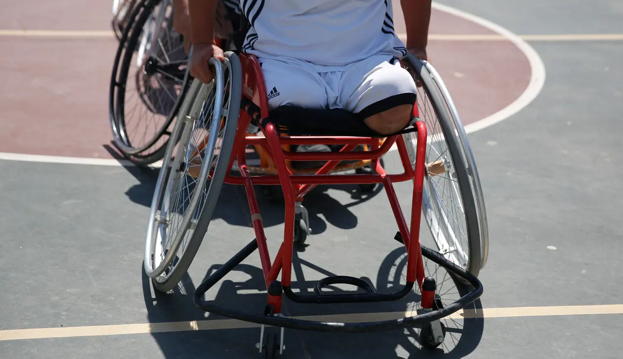 Seorang pria menggunakan kursi roda bermain basket di lapangan sekolah milik pemerintah di Kota Gaza (4/4). Meski telah kehilangan anggota tubuhnya, mereka tetap semangat menjalani hidup. (AP Photo/Hatem Moussa)