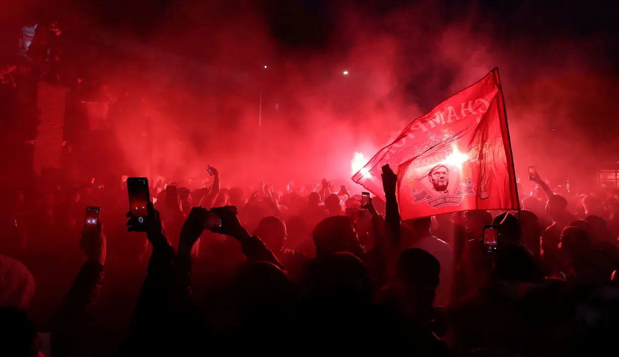Suporter Liverpool merayakan gelar juara Liga Inggris di luar Stadion Anfield, Liverpool, Inggris, Rabu (22/7/2020). Perayaan digelar setelah Liverpool menghadapi Chelsea. (Martin Rickett/PA via AP)