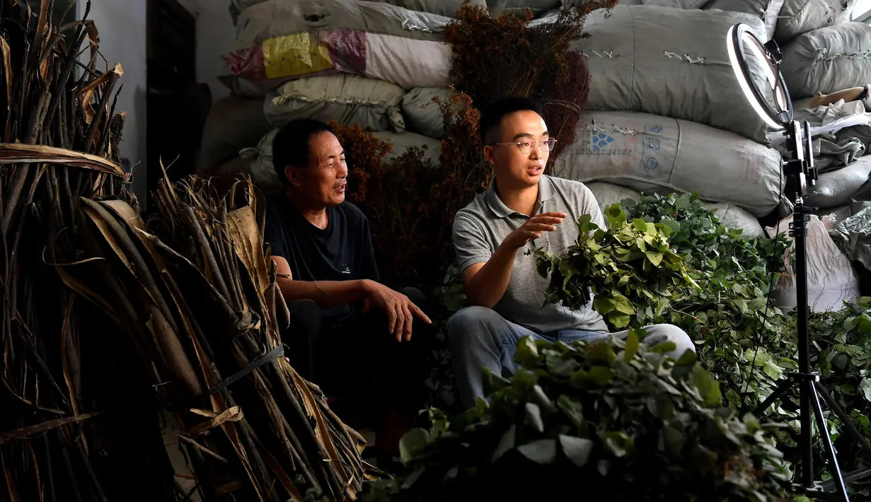 Pengguna layanan live streaming (kanan) membantu petani menjual produk rempah-rempah secara daring di Danfeng, Provinsi Shaanxi, China, 21 Juli 2020. Penjualan daring produk pertanian di sana mencatat kenaikan berkat aktifnya penduduk mempromosikan produk melalui live streaming. (Xinhua/Liu Xiao)