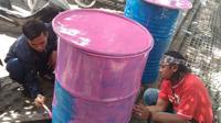 Bobotoh sedang mengecat drum menjadi warna pink yang akan diberikan kepada Komisi Disiplin PSSI. (Bola.com/Muhammad Ginanjar)