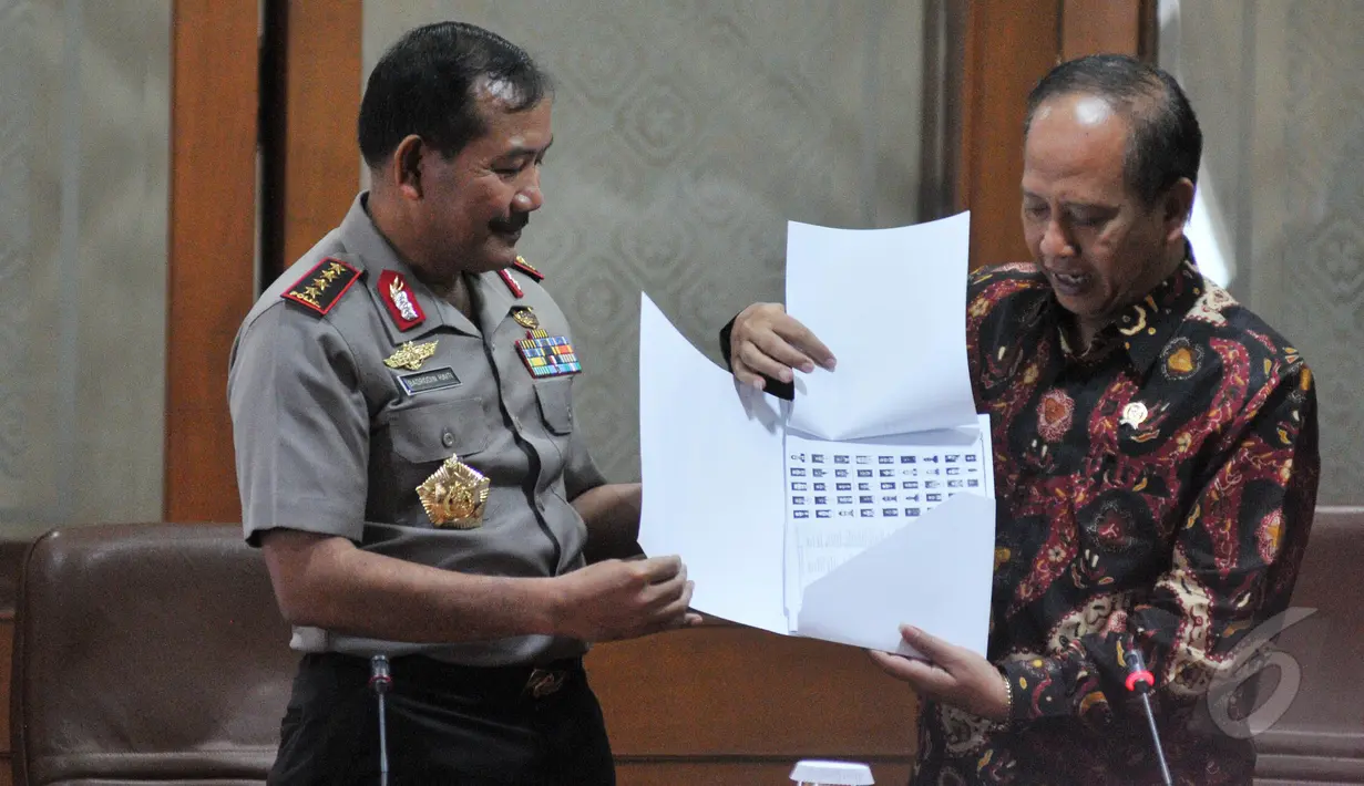 Menristek Mohammad Nasir memberikan dokumen berupa data perguruan tinggi ilegal kepada Kapolri Badrodin Haiti, Jakarta, Selasa (26/5/2015). (Liputan6.com/Herman Zakharia)
