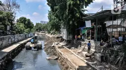 Petugas Sudin SDA Jakarta Pusat menggunakan alat berat saat pengerukan lumpur di Kali Sentiong, Kecamatan Johar Baru, Rabu (22/9/2021). Pengerukan lumpur Kali Sentiong sekaligus mencegah banjir di kawasan tersebut yang kerap terjadi saat musim hujan. (merdeka.com/Iqbal S. Nugroho)
