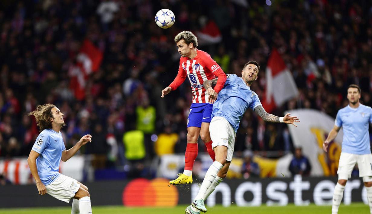 Pemain Atletico Madrid, Antoine Griezmann, duel udara dengan pemain Lazio, Matias Vecino, pada laga grup E Liga Champions di Stadion Metropolitano, Madrid, Kamis (14/12/2023). (AP Photo/Pablo Garcia)
