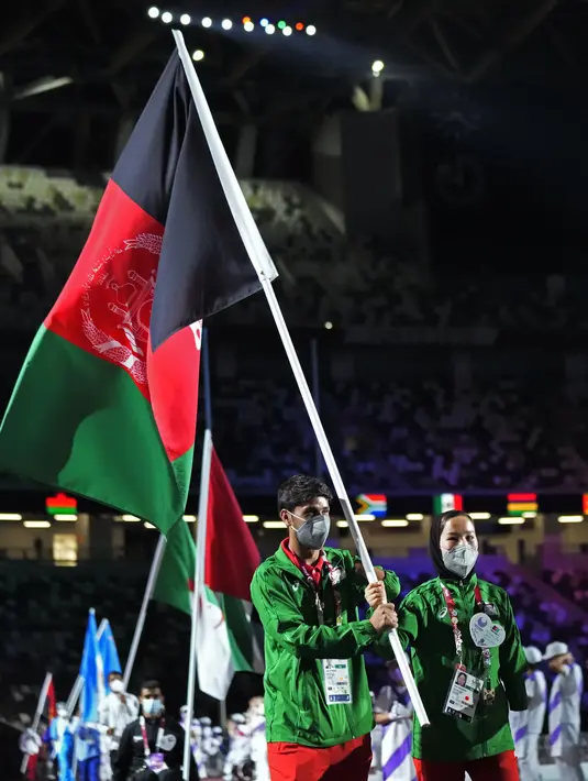 Para pembawa bendera Afghanistan memasuki stadion saat upacara penutupan Paralimpiade 2020 di Stadion Nasional di Tokyo, Minggu (5/9/2021). (AP Photo/Shuji Kajiyama)