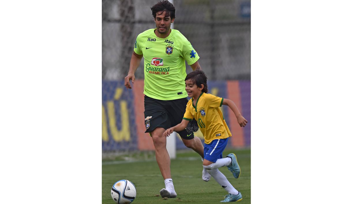 Kaka bersama putranya Luca berlatih bersama disela-sela pemusatan latihan jelang laga penyisihan Piala Dunia 2018 di Sao Paulo, Brasil, Selasa (10/11/2015). (AFP Photo/Nelson Almeida)