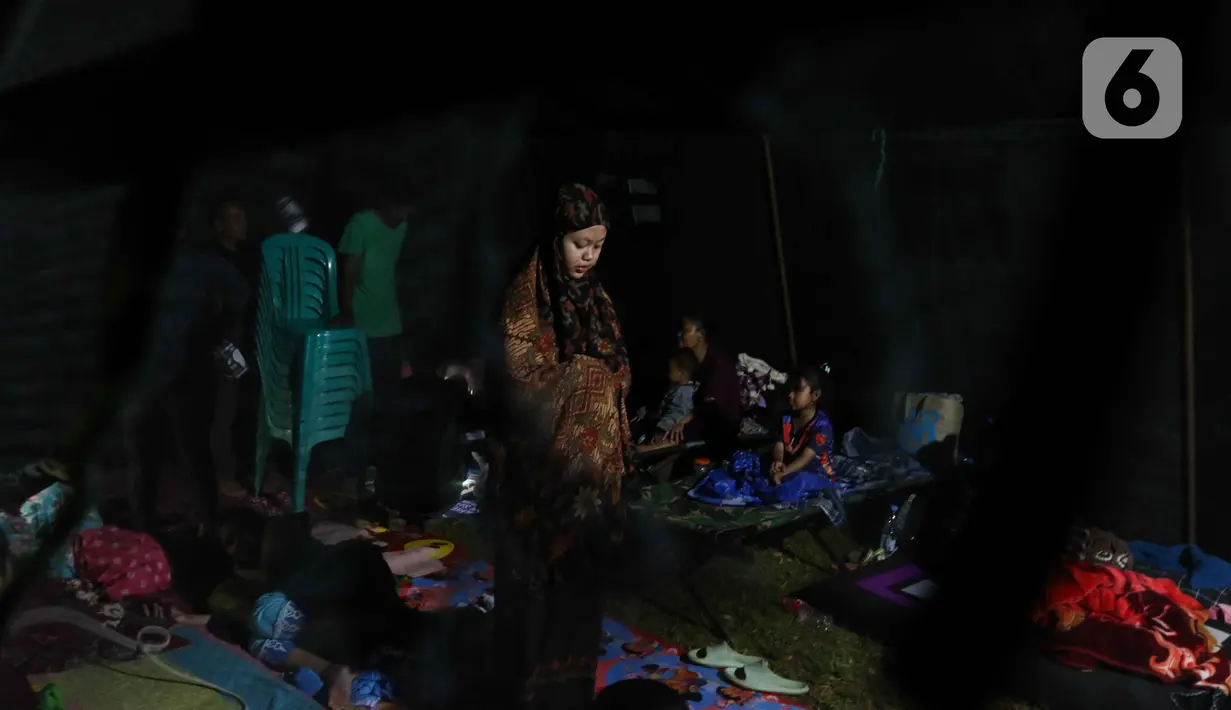 Seorang wanita melaksanakan Salat di posko pengungsian di Taman Prawatasari, Kabupaten Cianjur, Jawa Barat, Selasa (22/11/2022). Gubernur Jawa Barat Ridwan Kamil menyebut, sebanyak 14 posko pengungsian didirikan untuk memfasilitasi warga berjumlah 13.784 pengungsi yang terdampak gempa berkekuatan 5,6 SR di Kabupaten Cianjur. (Liputan6.com/Herman Zakharia)