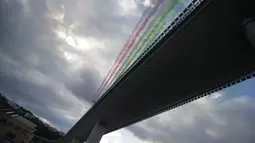 Tim aerobatik Angkatan Udara Italia, Frecce Tricolori (Panah Tiga Warna), terbang di atas Jembatan Saint George Genoa baru di Genoa, Italia, Senin (3/8/2020). Jembatan tersebut dibangun untuk menggantikan viaduk yang ambruk dua tahun lalu dan menewaskan 43 orang. (Xinhua/Stringer)